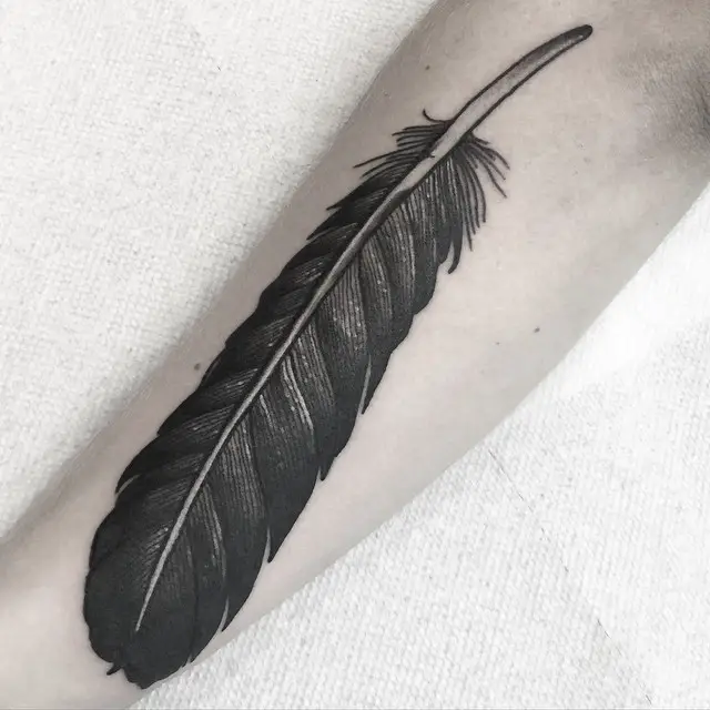 Black feather tattoos on arm