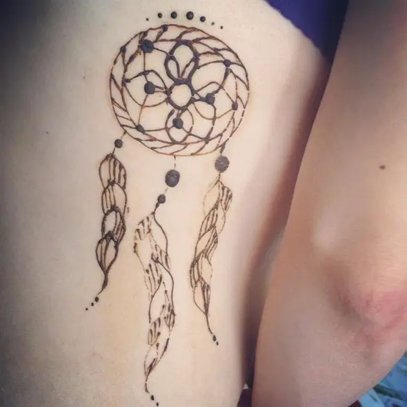 dreamcatcher tattoo on inside of leg on thigh of girl
