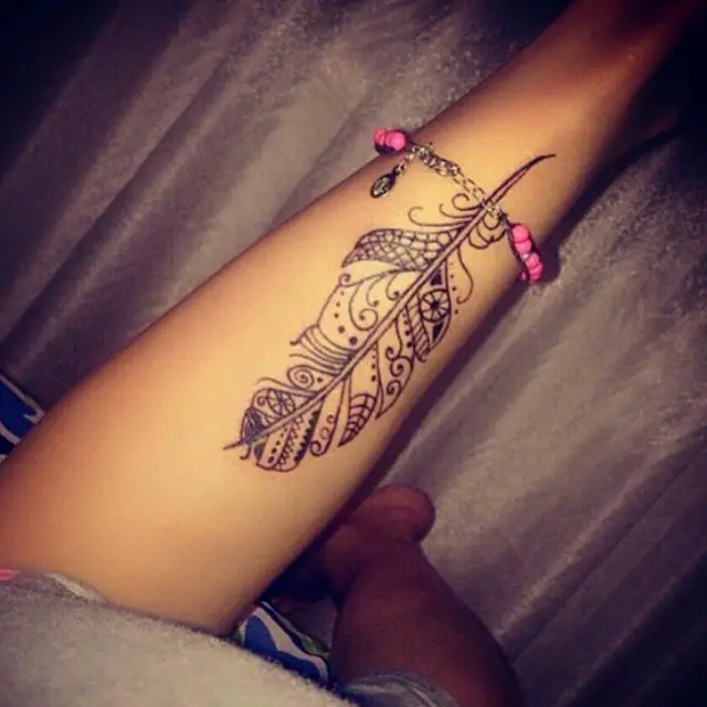 feather tattoo on thigh