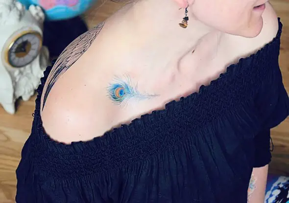 small blue peacock feather tattoo on collar bone
