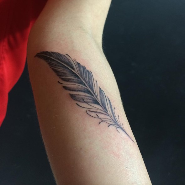 small eagle feather tattoo on arm