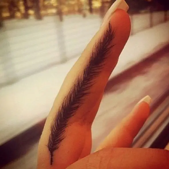 small feather tattoo on finger