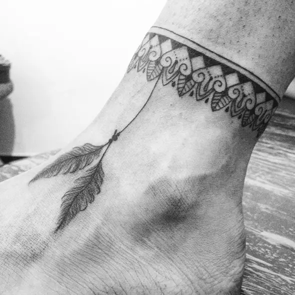 small native feather tattoo on foot