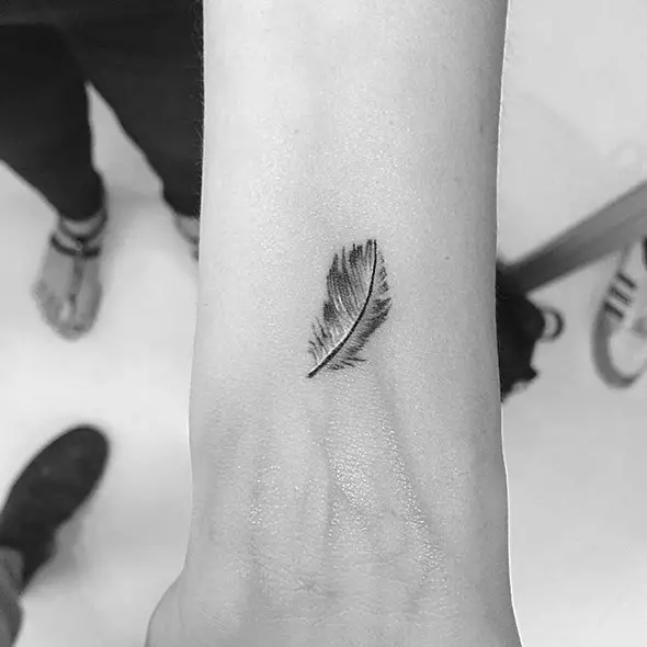 tiny feather tattoo on wrist