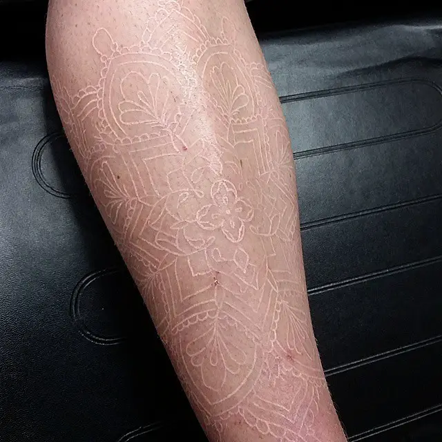 Healed half leg sleeve in white tattoo ink