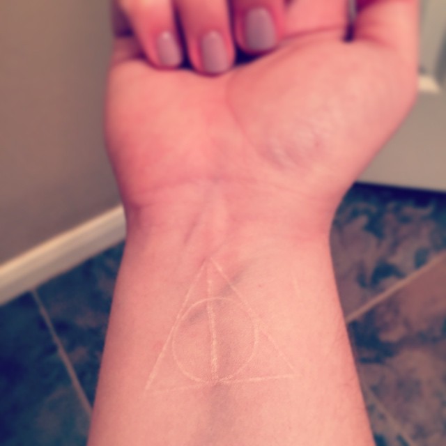 Deathly hallows symbol tattoo in white ink