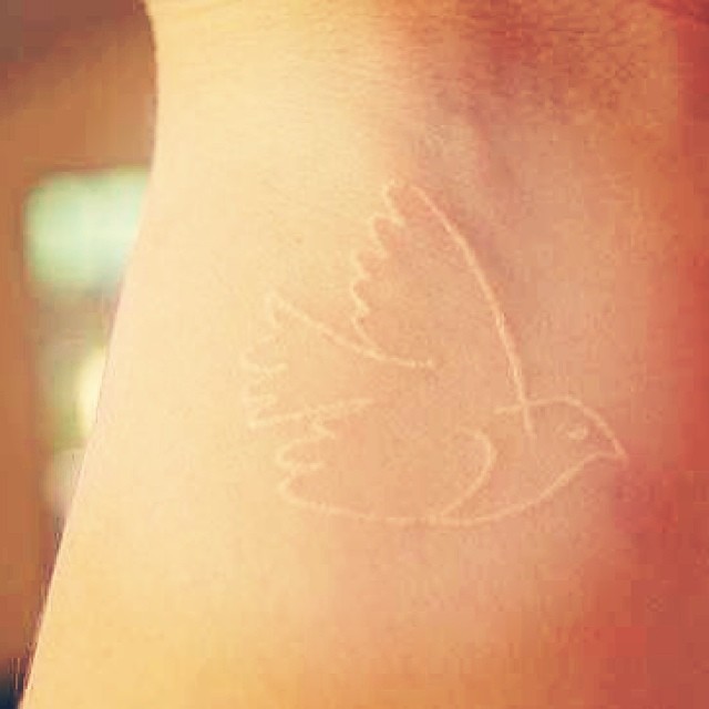 White ink bird tattoo