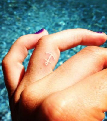 white ink tattoo on finger